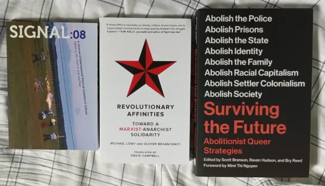 a photo of three books on a bed. the books are Signal №8, Revolutionary Affinities: Towards a Marxist-Anarchist Solidarity, & Surviving the Future: Abolitionist Queer Strategies.