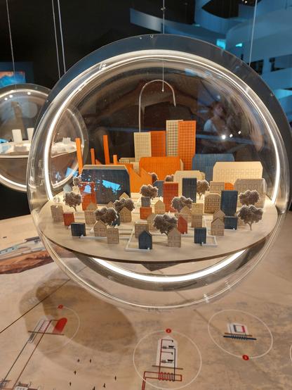 Eine Plastikkugel mit einer Holzstadt innen.