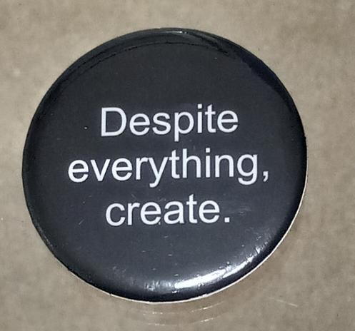 Black button inscribed with the message "Despite everything, create."