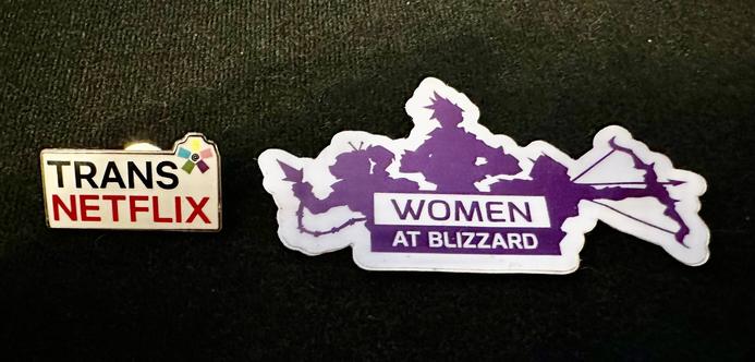 On the left, a Netflix Trans* ERG pin
on the right, a Women at Blizzard sticker
