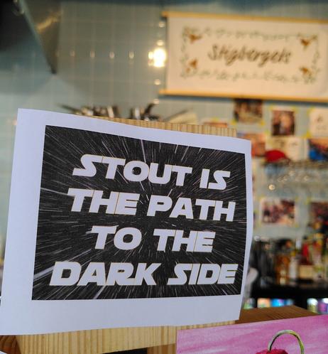 Tap beer label saying "Stout is the path to the dark side" and a banner of Stigbergets brewery in the background.