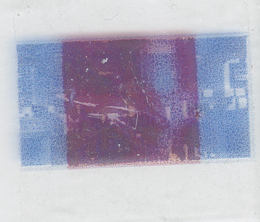 A microscope slide showing two images in red and blue, overlapping. These images have been damaged by scratching.
