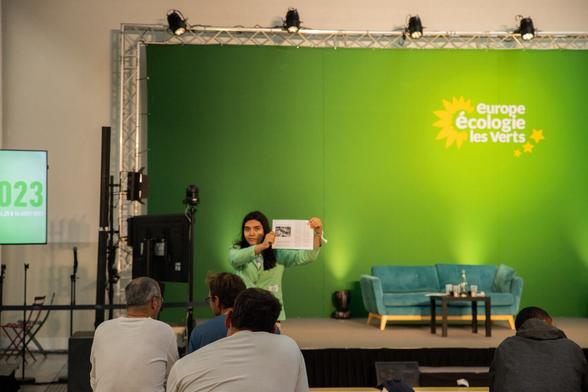 Lou Toussaint-Ianeva devant l'espace canapé brandit l'article Julien Bayou