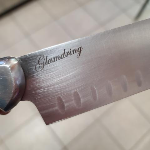 the word "Glamdring" is etched into the top portion of the base of the blade of a kitchen knife.