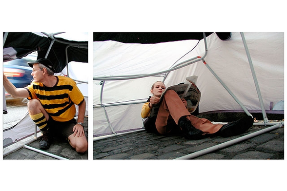 Exhibit by Michael Rakowitz in Vienna. A split image. On the left, the person looks out of the tent door. In the second, the person sits inside the tent, on the cobblestones, reading a newspaper. 

We're conditioned to see this behavior as selfish and as taking public space away from others, and yet if they were in a car most people would think nothing of the same behaviors.
