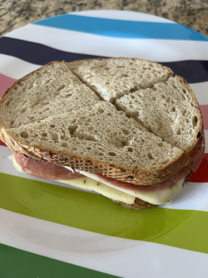 Sandwich cut it n triangles on a colorful striped plate