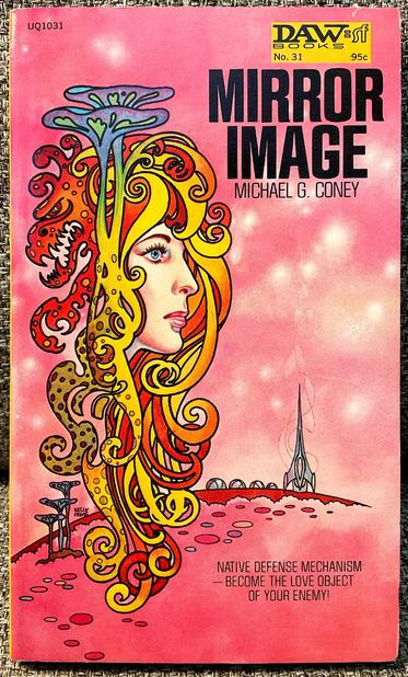 “Mirror Image” by Michael G. Coney, DAW Books #31, 1972.

As a spaceship stands ready for takeoff on a futuristic landscape, a beautiful face covered by a kaleidoscopic headdress hovers above.
