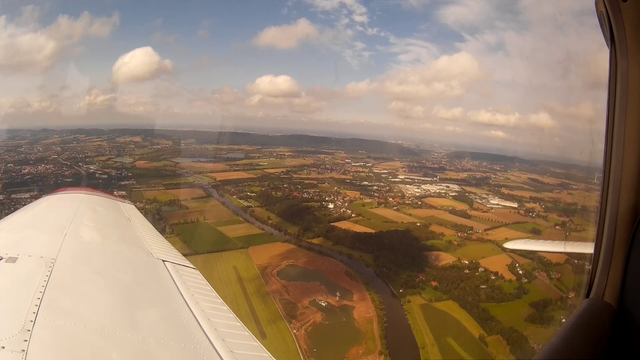 Airplane wing in view of the plains of Westphalia with the Wiehen hills in the background near the airfield of Porta Westfalica