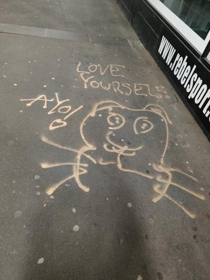 Tagging on concrete saying "love yourself" and a weird drawing of a critter of some kind