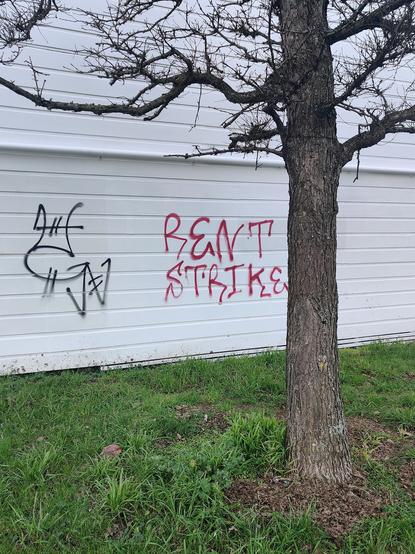 Rent strike tagged in red paint on a white building