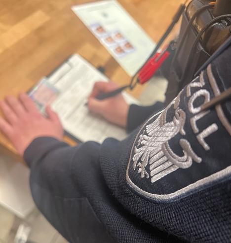 Ein Zöllner bei der Erfassung von Personendaten im Rahmen einer Mindestlohnprüfung. (Symbolbild)