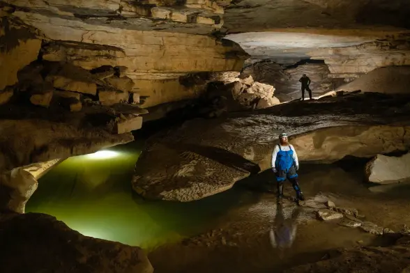 photo of 2 people standing in a cave