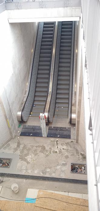 Rolltreppe mit Blick von oben, mit noch unverputzten Wänden außenherum.