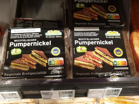 Ein Foto von zwei Packungen Westfälischer Pumpernickel. Ein Packung beinhaltet 250 Gramm, die andere 500g. Die Packung mit 250 Gramm hat einen Nutriscore von B, die 500 Gramm Packung hat einen Nutriscore von A.