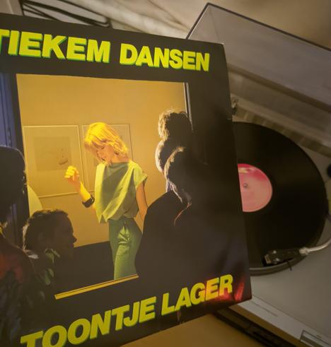 Me holding the vinyl sleeve and standing in front of the record player.