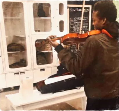 Photograph of Elijah McClain playing his violin for the "lonely kittens" at the shelter.