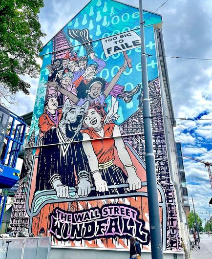 Streetartwall. On the outer wall of a multi-storey modern building has been sprayed / painted a mural with a group of people in a roller coaster. The mural is designed in comic book style and shows a society of young people, the party mood with a roller coaster rushing into the depths. To recognize are the "Wolf of Wallstreet", next to it a kind of Marilyn, further back a politician with campaign hat. A black woman holds up a sign with the text "Too big to fail" in the air. Below it is the title "Wall Street Windfall."
The Western world rushes merrily into the abyss.