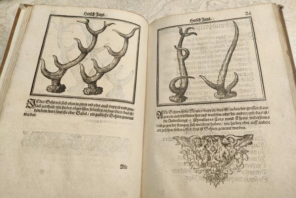 Woodcuts of pairs of antlers, with text and an ornate device below, presented as if relics.