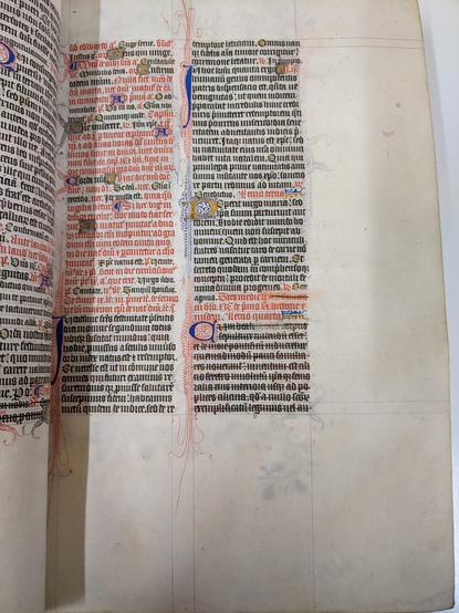 Manuscript page with red and black ink. Elaborate flourishing around decorated letters. Lower right quadrant of text struck through.