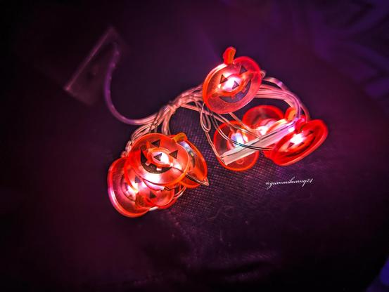 a cluster of pumpkin lights laying on the bed