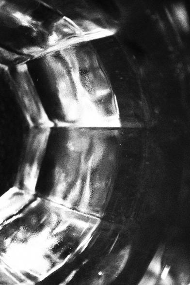 Close-up of a section of an inner side of a glass.  Light is shining through and reflecting on the bevelled corners and edges.