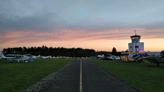 Middle of the taxiway. Tower to the right. Aircraft and tents in the back.