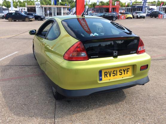 Yellow/green metallic first-generation Honda Insight, rear view