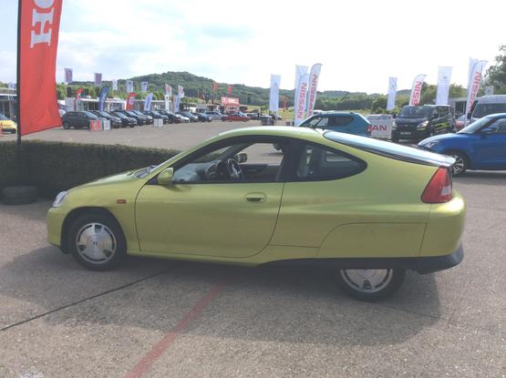 Yellow/green metallic first-generation Honda Insight, side view