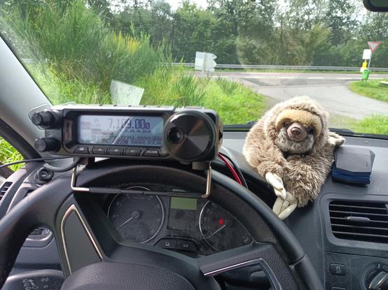 Blick durch die Frontscheibe des Funkmobils. Auf dem Lenkrad läuft das Funkgerät, daneben wacht Faultier Stubbsi.