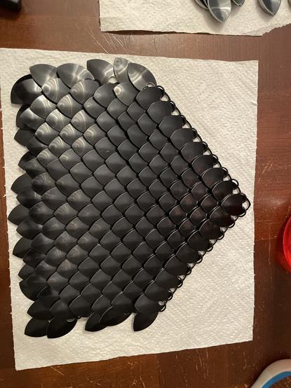 A trapezoidal work of black scale mail