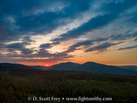 Sunset through smoke behind mountains