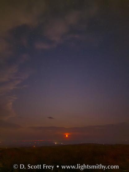 Moonrise through smoke over the plains