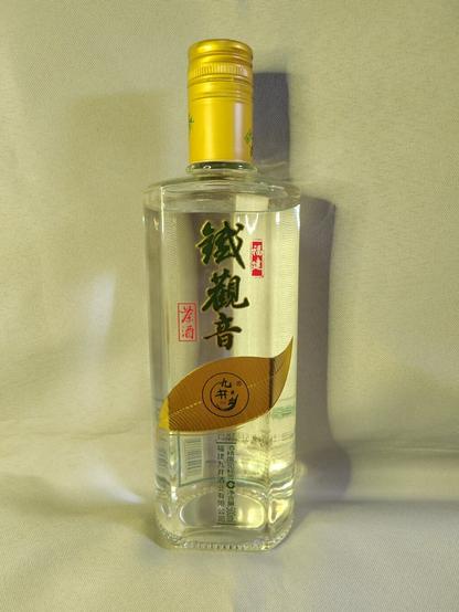 Front view of the bottle.  From the Taobao description of the product:

九井乡福建铁观音茶酒浓香白酒正宗纯粮固态52度口粮500ml 

Jiujing Township Fujian Tieguanyin Tea Wine Luzhou-flavored Liquor Authentic Pure Grain Solid 52 Degree Ration 500ml