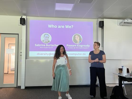 Sabrina Burtscher (PhD student at KIT) and Passant Elagroudy (PostDoc at DFKI Kaiserslautern)
standing in front of an introductory slide.