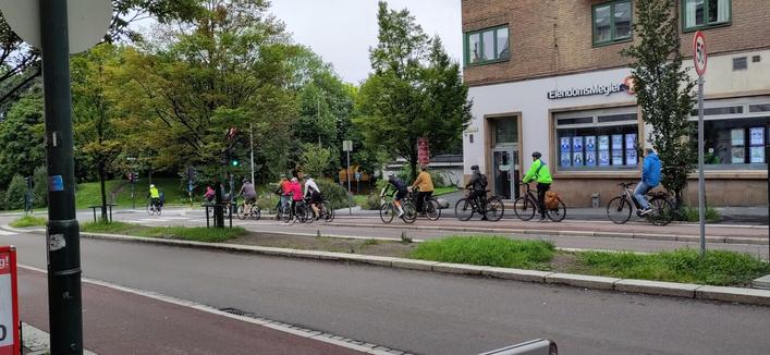 10 syklister i sykkelfeltet nedover ved blokka på Galgeberg, ventende på grønt lys.