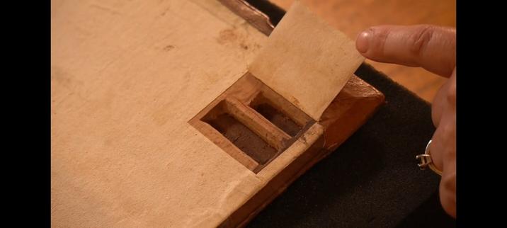 Secret compartment in the back of a 16th c. book, flap open.