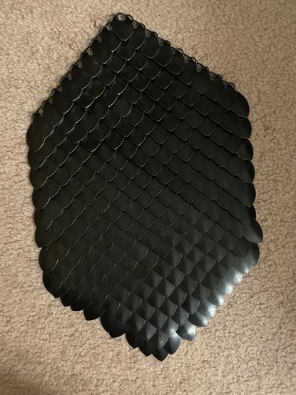 A hexagonal section of black scale mail
