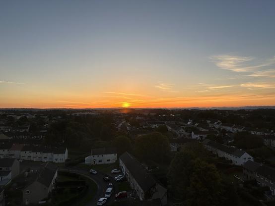 View of the setting sun, across the town , from my window on the eleventh floor.