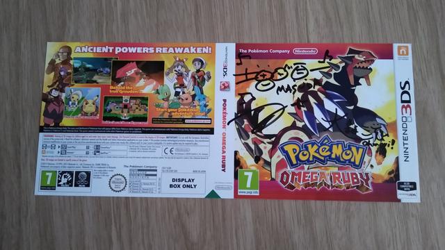 A signed sleeve of Pokémon Omega Ruby, featuring two autographs on the front from Junichi Masuda, and Shigeru Ohmori