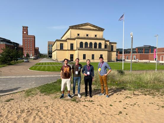 Group of four people with building in the back
