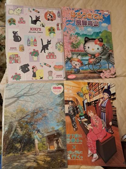 Foto de cuatro carpetas compradas en mi reciente viaje a Japón: una con imágenes de "Nicky, la aprendiz de bruja" (Kiki's Delivery Service), otra de Hello Kitty con ambientación en Hida Takayama, una de "Love Live - School Idol Project" y, finalmente, una de las chicas de la campaña "Chikatetsu ni noru" del metro de Kioto.