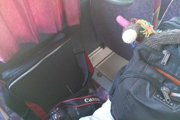 Strickhorn, Rucksack, Fototasche und Kamera im Bus.