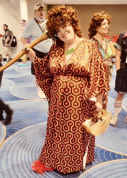 Heather Miller cosplaying Helen Roper from "Three's Company" with an axe and kaftan pattern from "The Shining"