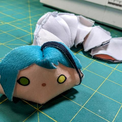 a string of stitched plush heads with a slightly squashed Jade Leech at the front