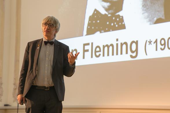 Metin Tolan vor einer Folie zu Ian Fleming.