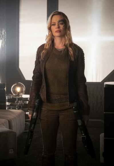 Jeri Ryan dressed as Seven of Nine in Picard S1. She's wearing her ranger outfit, holding two rifles, and being a badass blond bombshell.