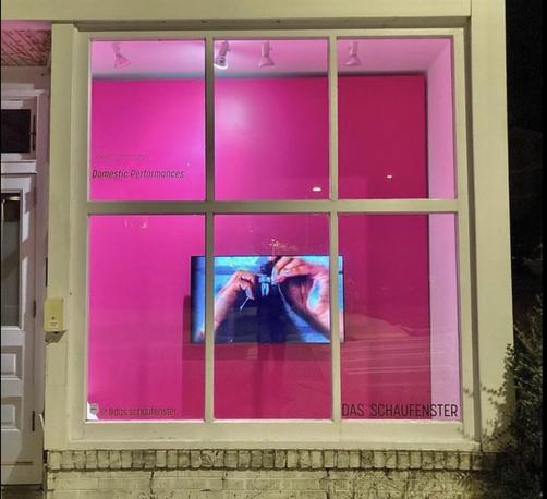Das Schaufenster Gallery Instagram color photo shot from street through their window showing artwork by Jaleesa Johnston in front of brilliant magenta wall of two brown hands