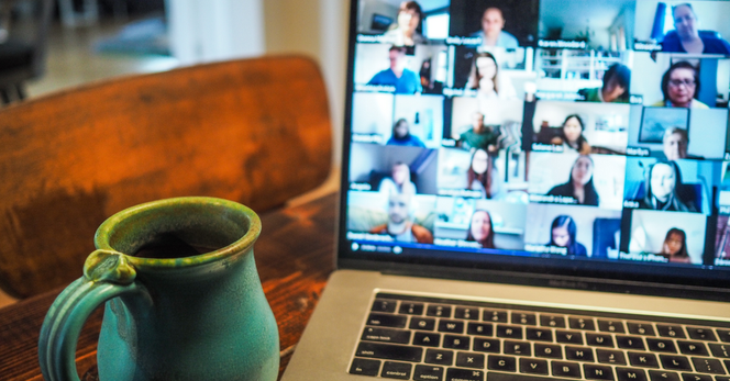 Alt: A handmade mug sits next to a laptop. On the screen is a group video chat.