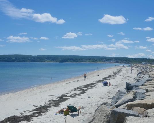 A view southward along Plymouth Long Beach, with the varied boulders of the seawall at right.