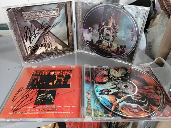 Two Iron Maiden compact disc albums, The X Factor (1995) and Virtual XI (1998), with their cases open, showing the last pages of their booklets, both having Blaze Bayley's autograph with black ink, 2010 Brasil.